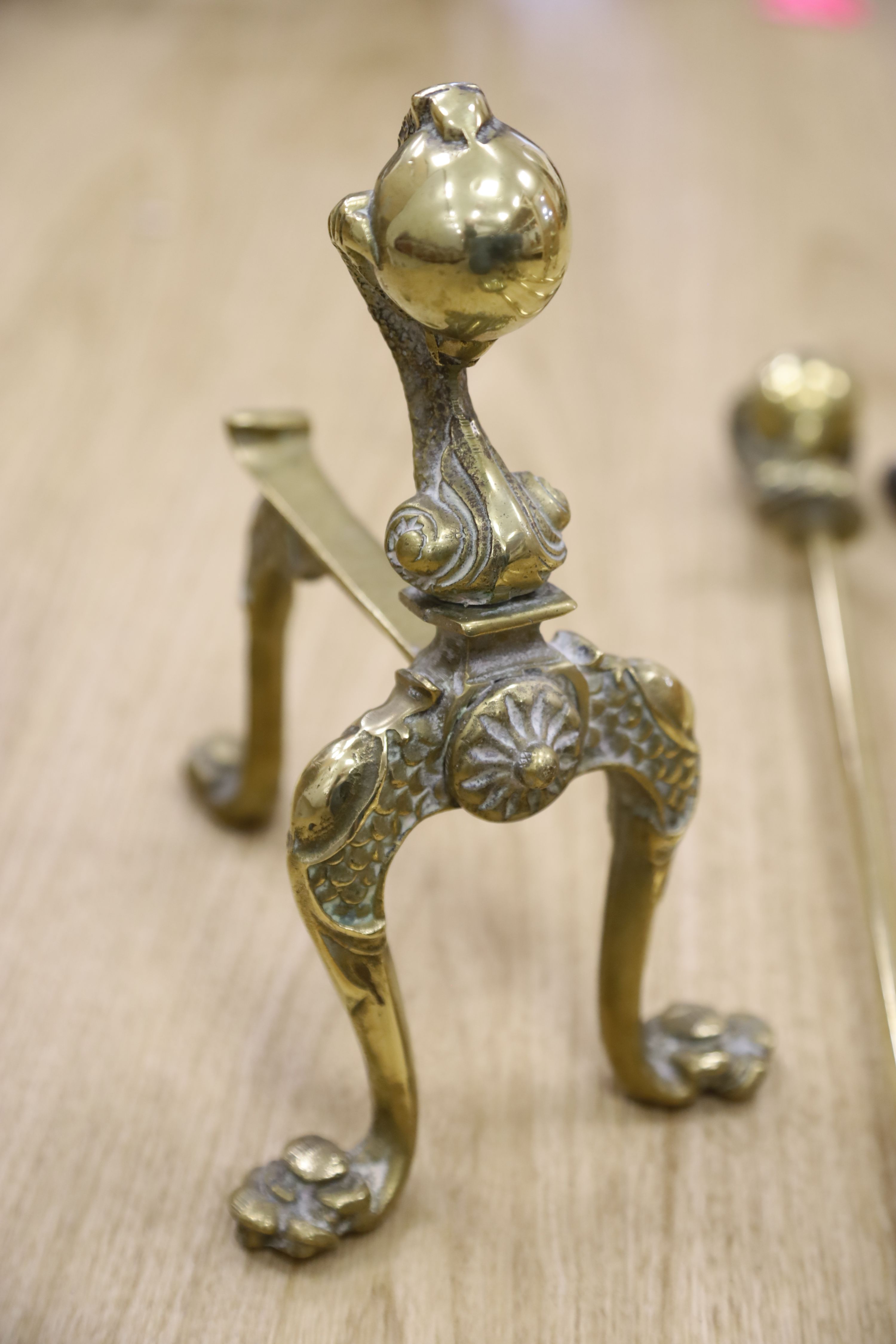 A set of three brass claw and ball fire implements and dogs